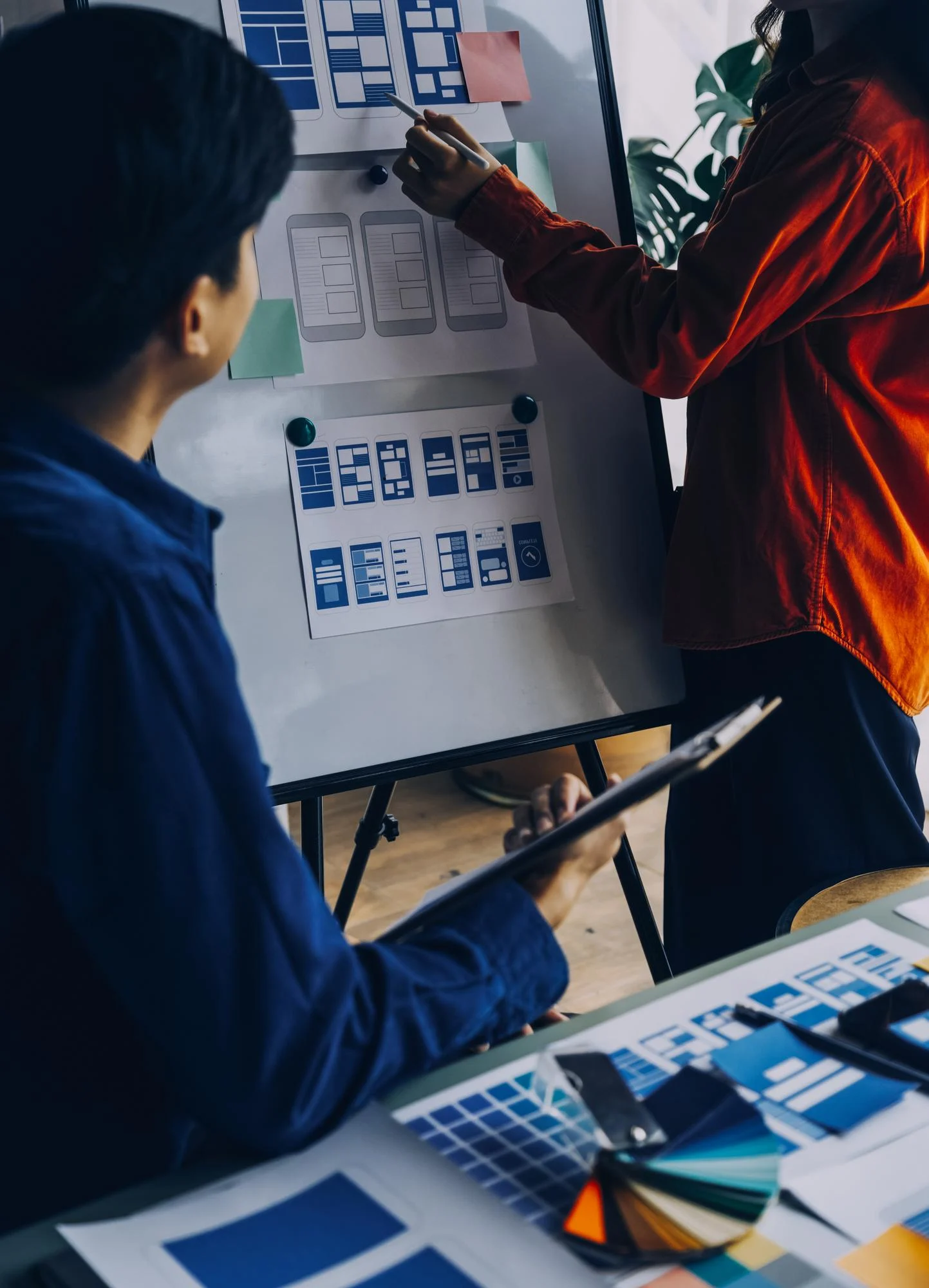 Pixerts design team is conducting industrial UX services by wireframing B2B manufacturing website architectures on a whiteboard to optimize user flow.