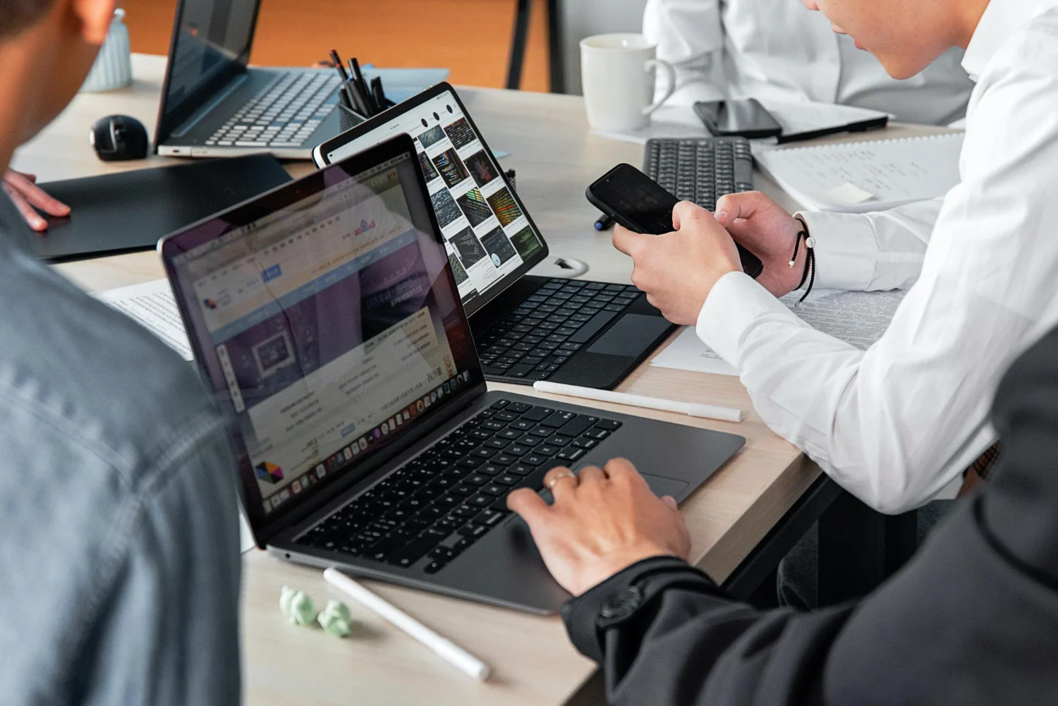 A B2B web design agency team developing a responsive manufacturing website across multiple devices, focusing on industrial SEO and high-performance UI/UX.