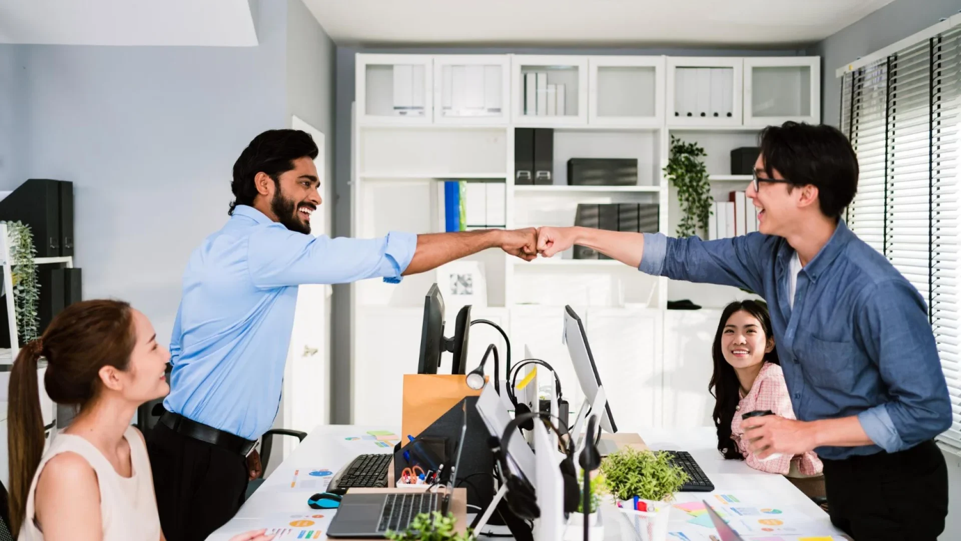 A manufacturing executive shaking hands with a technical consultant in a warehouse, symbolizing the value of hiring a specialized B2B web design agency for industrial SEO and manufacturing marketing.
