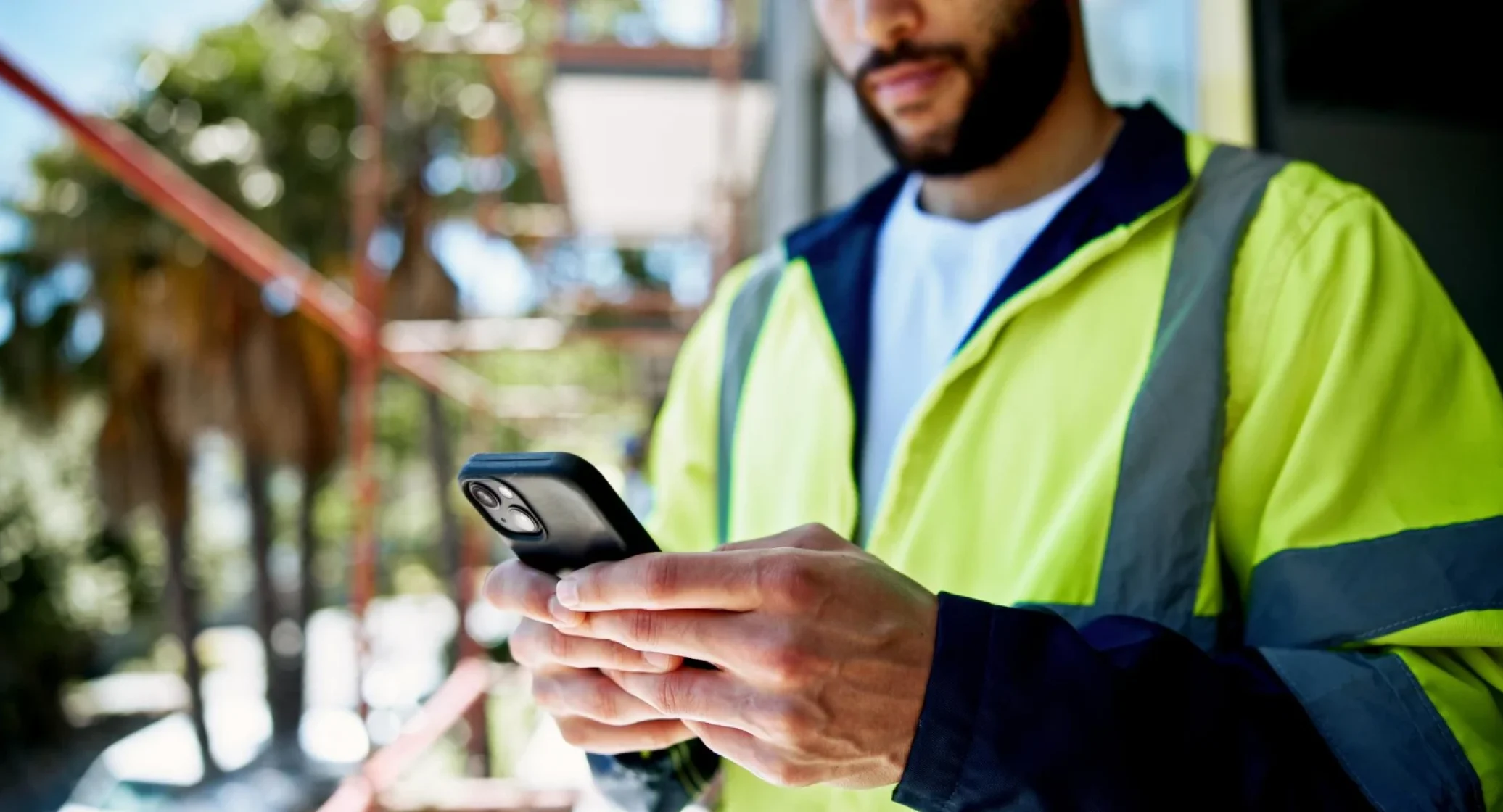 Industrial worker using a mobile device to access a responsive manufacturing website designed by Pixerts, a B2B web design agency.