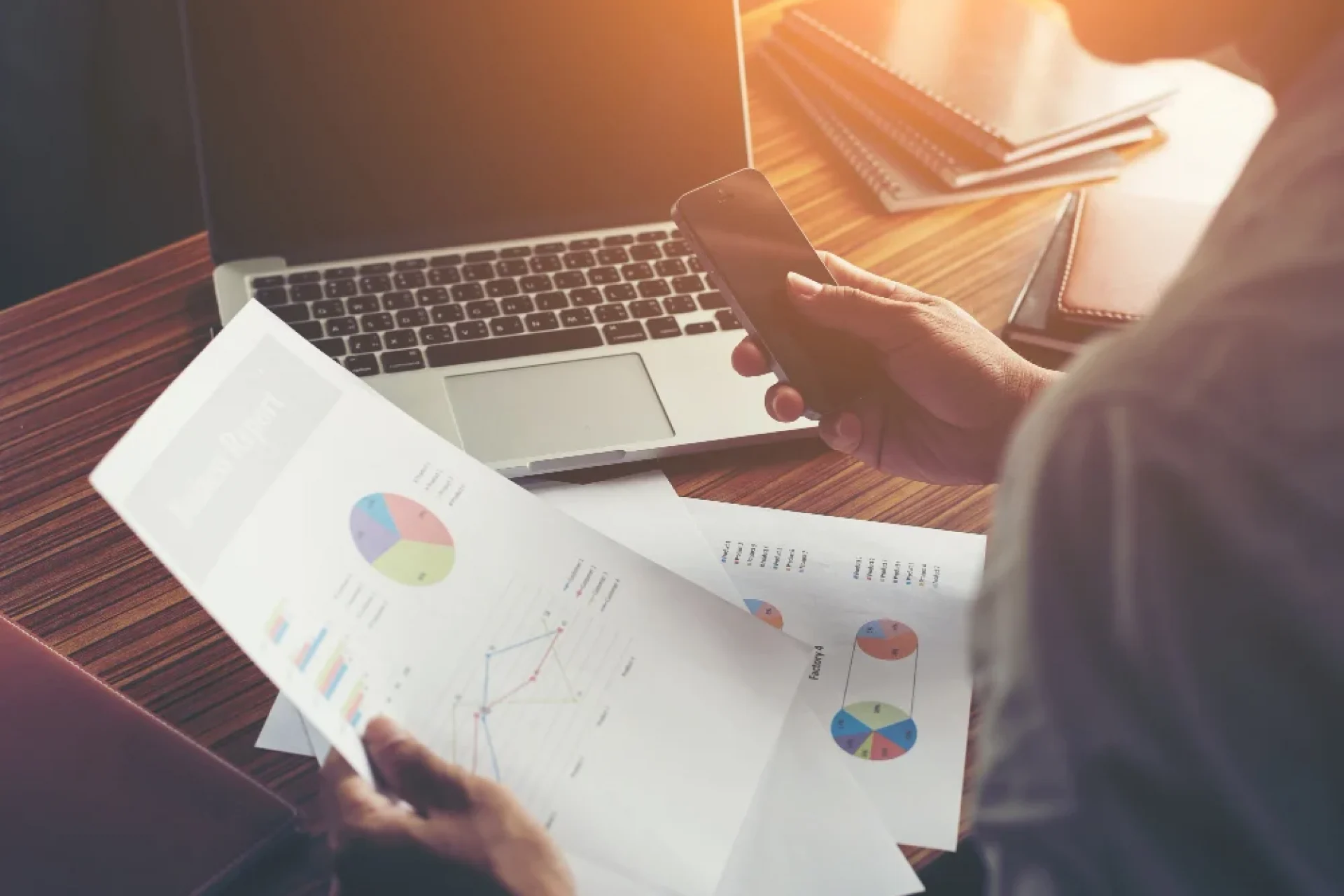 B2B industrial project manager performing a technical review of business reports and data charts.